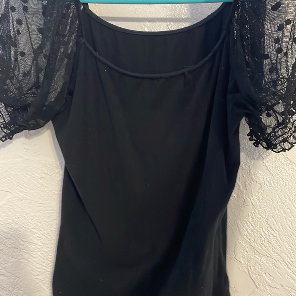 A long top, black polka dots on see through sleeves